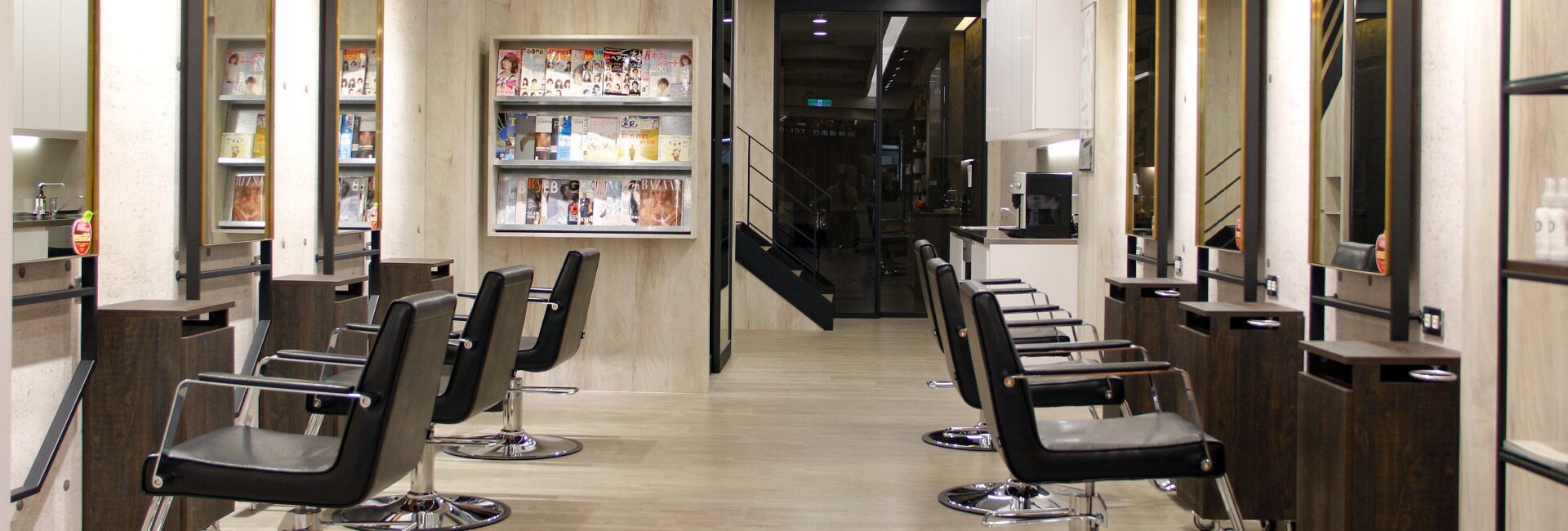 HAPPYHAIR 豐原2 主樓層，兩側木紋鏡台與黑色皮革座椅，中央走道通往後方